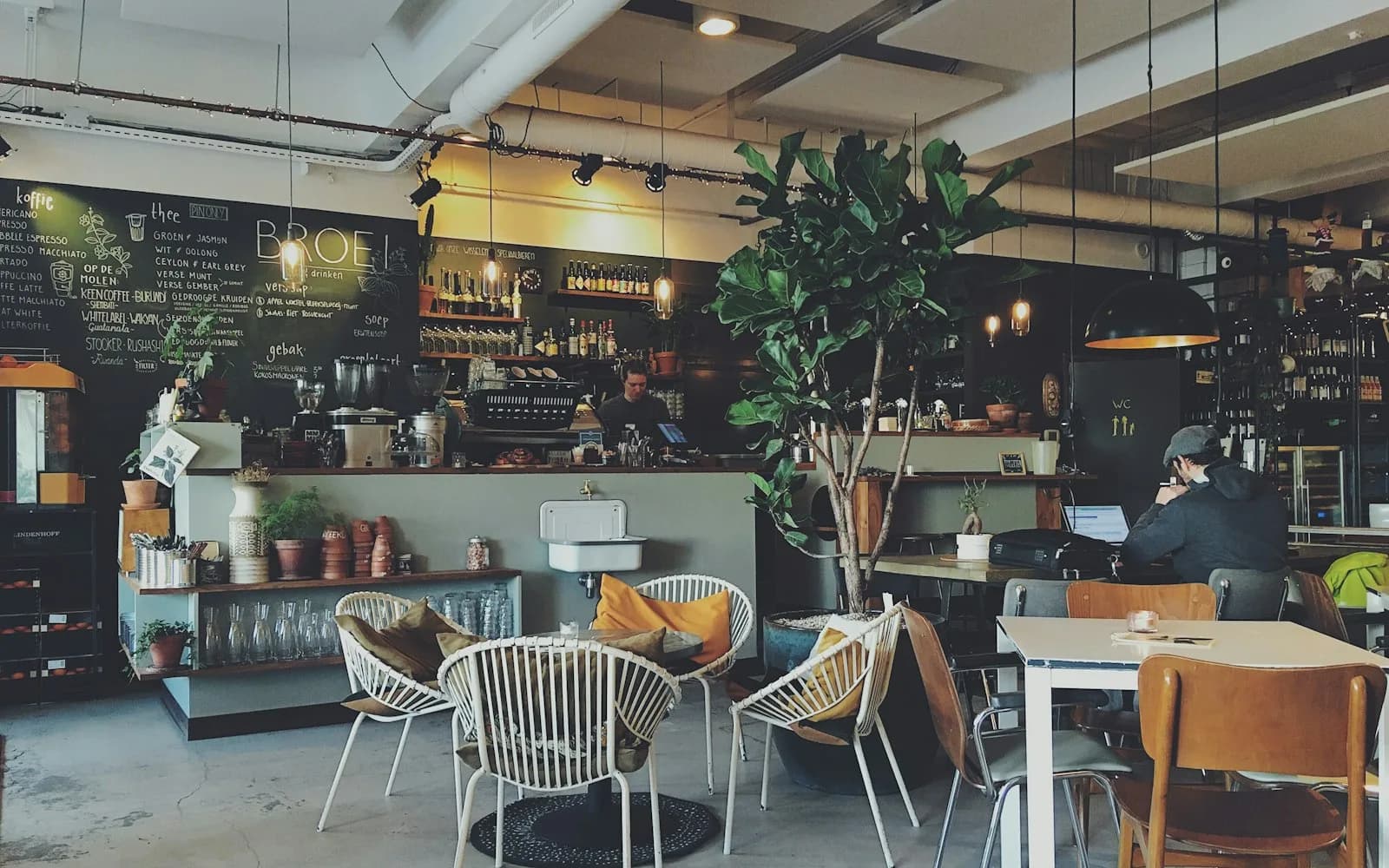 Atmosfer interior ruang Cafeice dengan meja kayu hangat dan pencahayaan alami